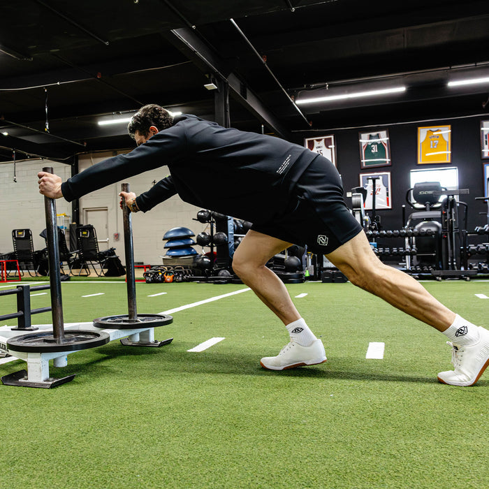 Person performing a workout with gym equipment in a fitness center.