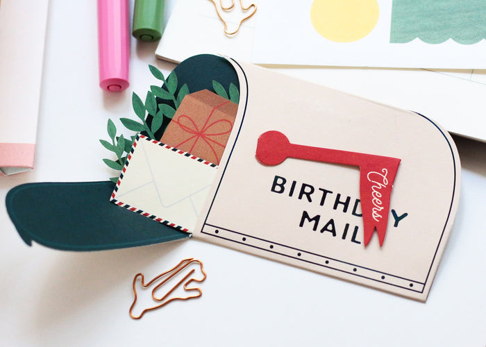 Birthday mail pop-up card close-up with red handle, BIRTHDAY MAIL text and kraft envelope
