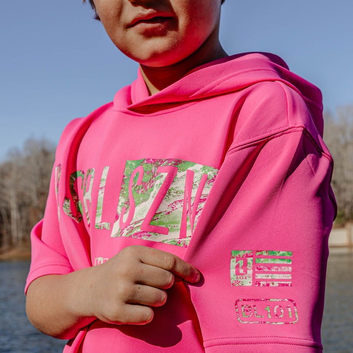 Person wearing a pink hoodie with pink and green BL101 logos outdoors