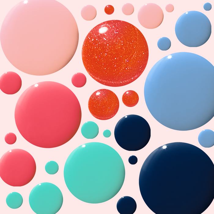 Various nail polish drops in coral, pink, blue, and teal shades from the Summer Polish Set by Olive and June on a pale background