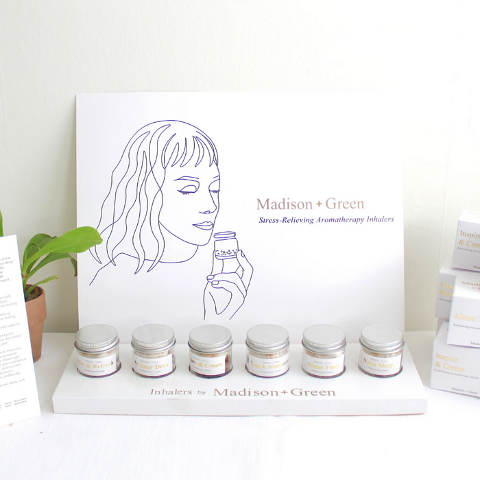 Aromatherapy inhaler display with illustrated yoga inhaler card and several small jars