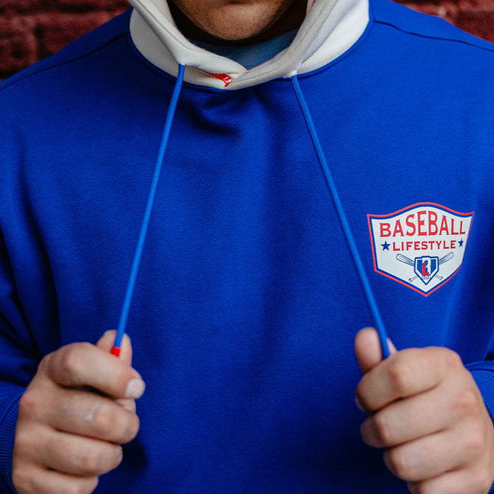 Close up of royal blue champions hoodie chest graphic with hands pulling the drawstrings