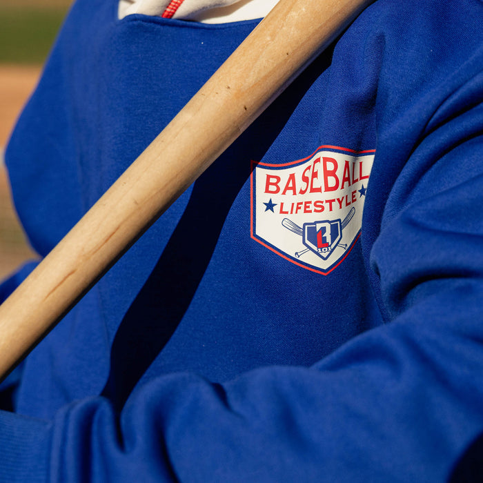 Close up of royal blue champions hoodie Baseball Lifestyle shield chest graphic with a bat resting across the chest