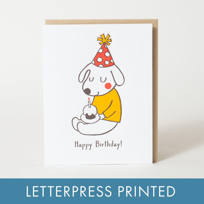 Happy Birthday birthday card with a dog holding a candle and wearing a party hat