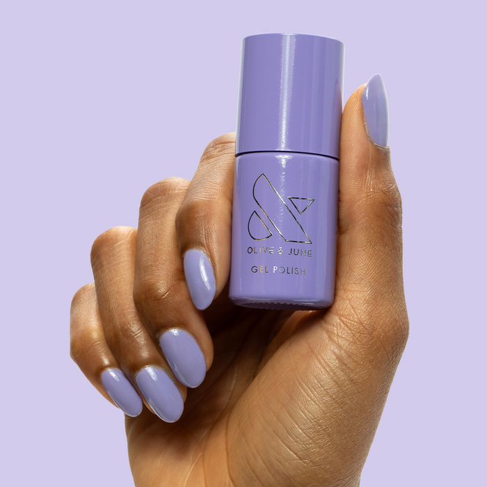 Bold & Unshaken - Gel bottle held with matching bold purple gel polish on nails for a long-lasting manicure by Olive and June