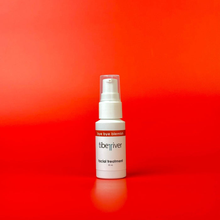White spray bottle with red label on a red background