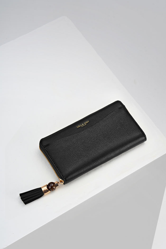 Overhead view of the front of Capriana Black faux leather Large Purse with mini Thames Tassel detail on the zip