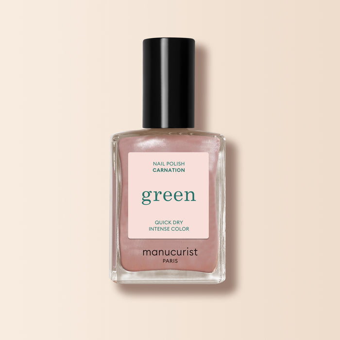 A bottle of Manucurist nail polish in the shade Carnation, with a black cap and Green™ range quick dry intense color label, set against a soft beige background.