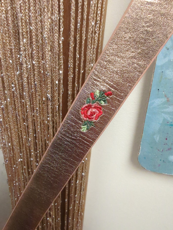 Joia Champagne & Roses belt with elegant floral design, featuring a sleek strap and decorative roses for a sophisticated look.