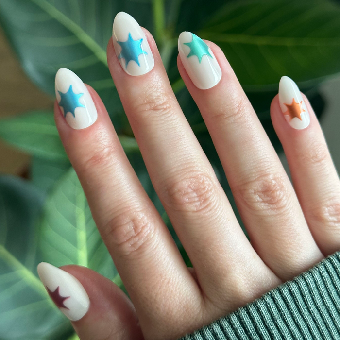 Chrome Burst - Press-On | Medium | Almond with neutral base and colorful chrome starburst accents on natural nails outdoors