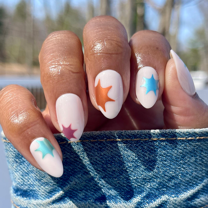 Chrome Burst - Press-On | Medium | Almond neutral press-on nails with colorful chrome starburst accents on hand outdoors