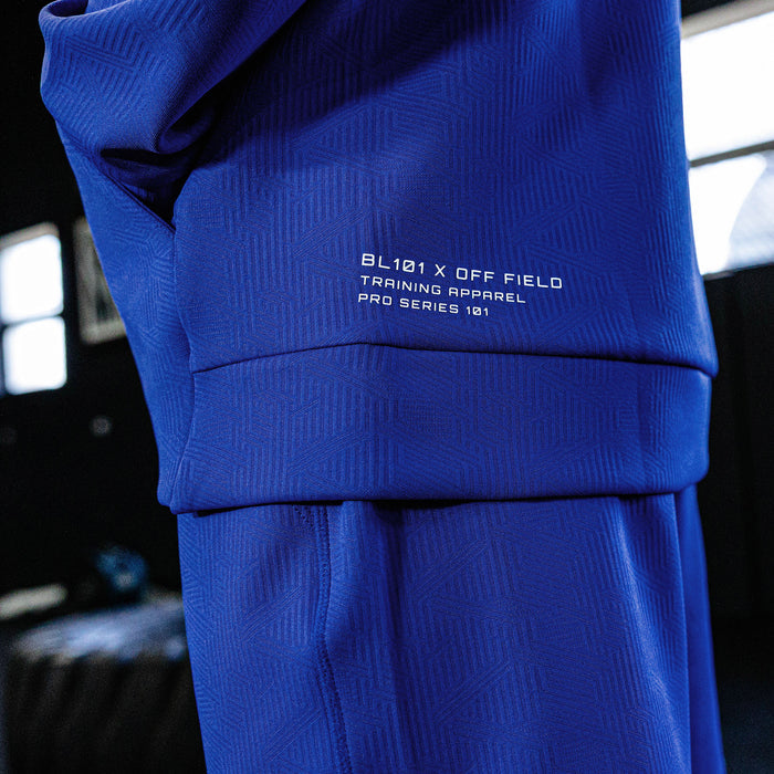 Blue athletic outfit with branding on a blurred indoor background