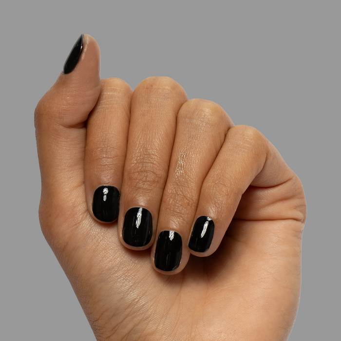 E+M - Gel nails with glossy deep black polish on short, rounded nails for a sleek and long-lasting manicure by Olive and June
