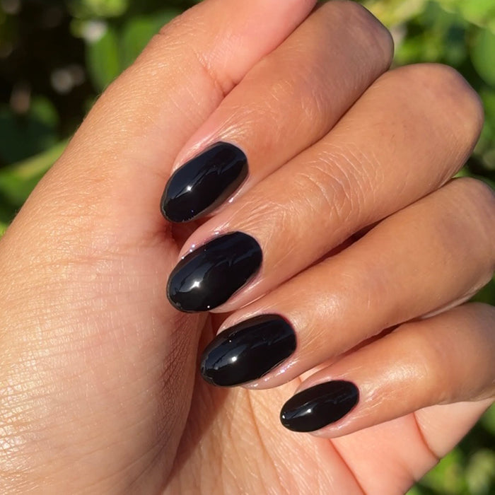 E+M - Gel shown on hand with glossy, deeply pigmented black nails for a chic, long-lasting gel polish manicure by Olive and June