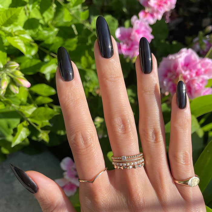 E+M - Gel shown on hand with glossy deep black gel polish on long nails for a chic manicure by Olive and June