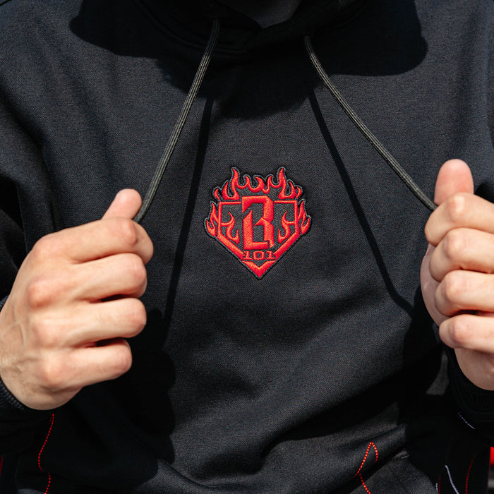 Close-up of red BL101 flame crest embroidery on the chest of a black hoodie
