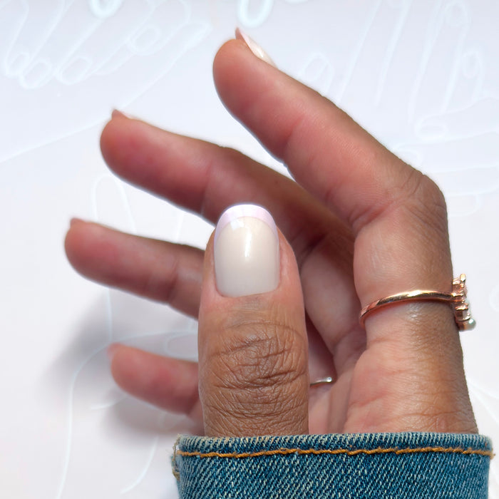 Glazed French | Short | Round - Tab Press-On with shimmering chrome French tip on short round false nail worn on thumb