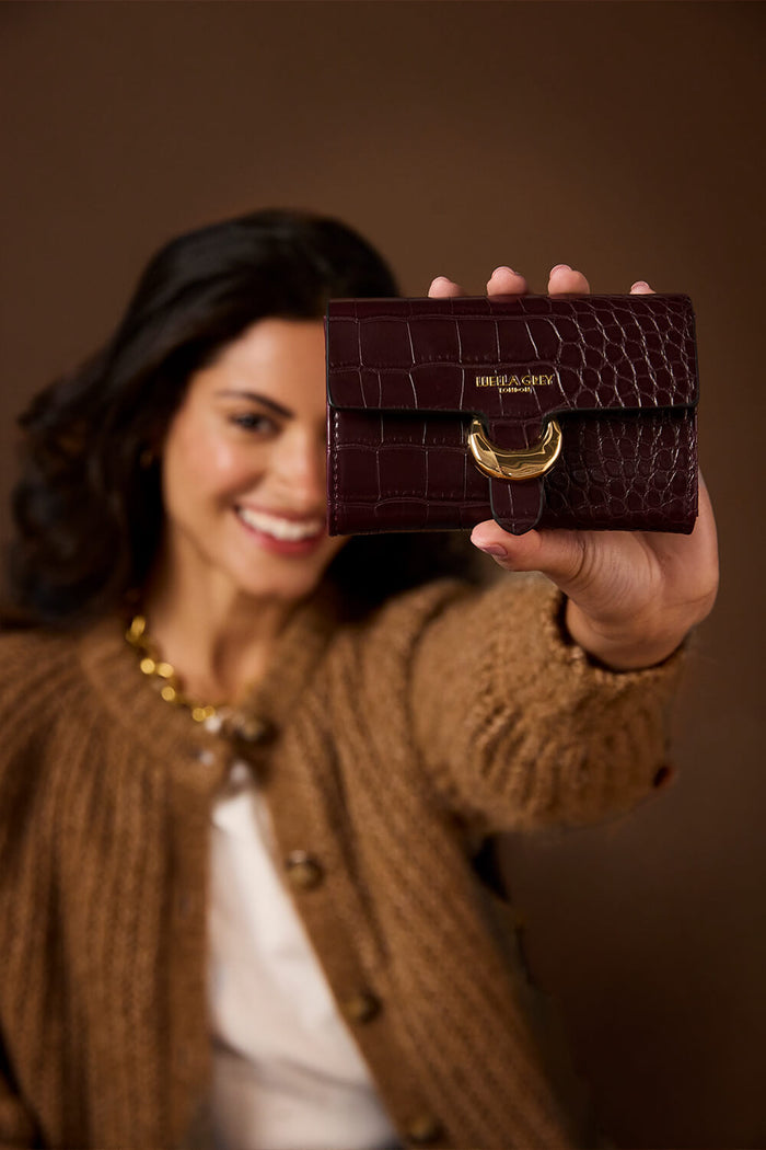 Female model holding Letitia Black Cherry Crocodile print faux leather Medium Purse with one hand