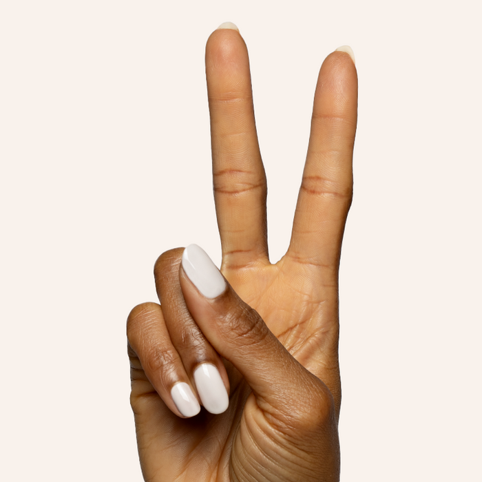 Hand with almond-shaped nails painted in soft muted grey with pink undertone using LHG - Gel polish on light background