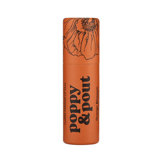 Orange lip balm tube with decorative floral top and bold typography label