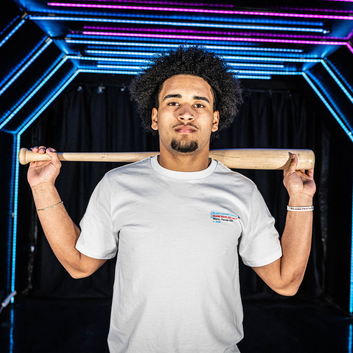Adult model wearing white graphic tee with "Miami Marlins Drip" design