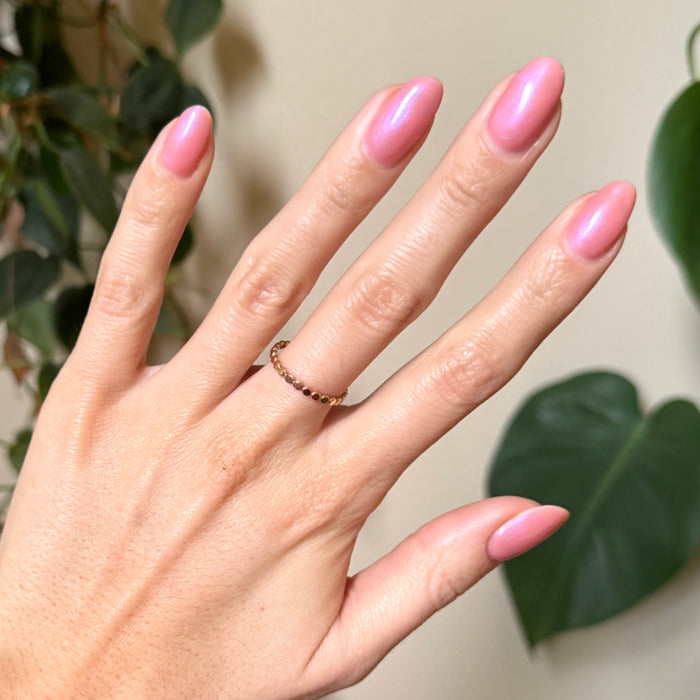 Hand with almond-shaped nails painted bright bubble gum pink-blue iridescent using Olive Y’all - Gel polish