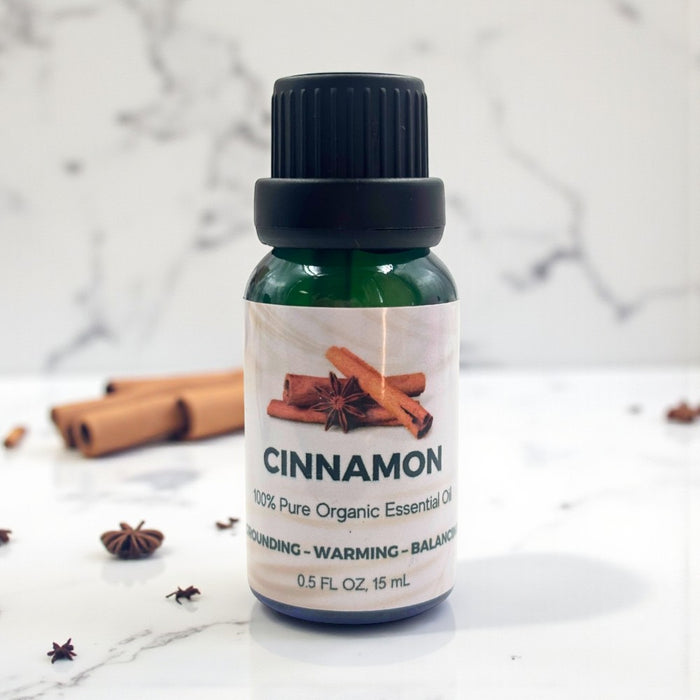 Bottle of cinnamon essential oil with cinnamon sticks on a marble background