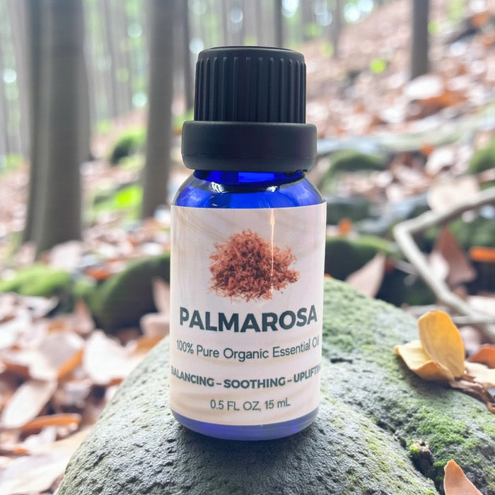 Palmarosa essential oil bottle on a rock with a forest background