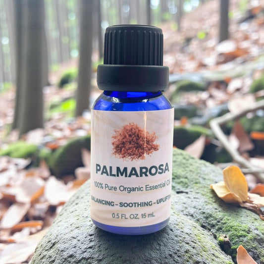 Palmarosa essential oil bottle on a rock with a forest background