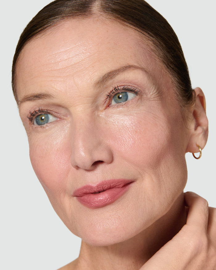 Close up of a model wearing Paige Liquid Silk Eyeshadow on a neutral background