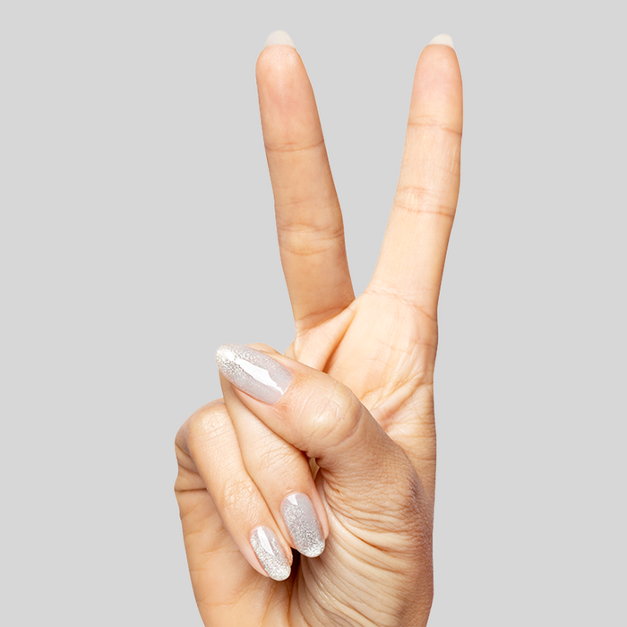 Hand showing nails painted with Platinum Velvet - Gel sheer silver shimmer polish in peace sign gesture