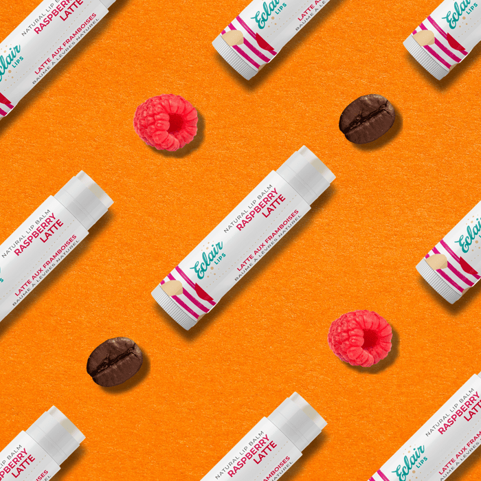 Raspberry Latte lip balm flatlay with coffee bean and raspberry.