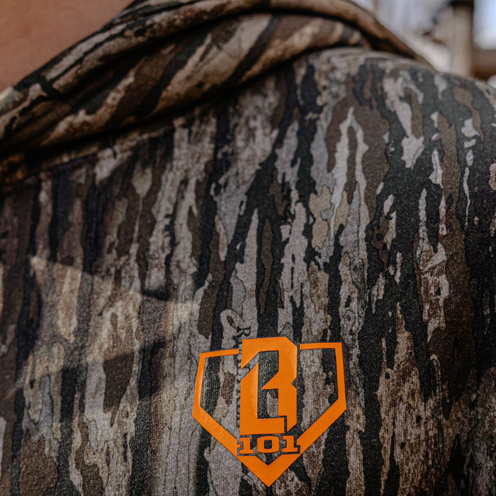 Close up of camouflage hoodie with a orange BL101 logo on a blurred background