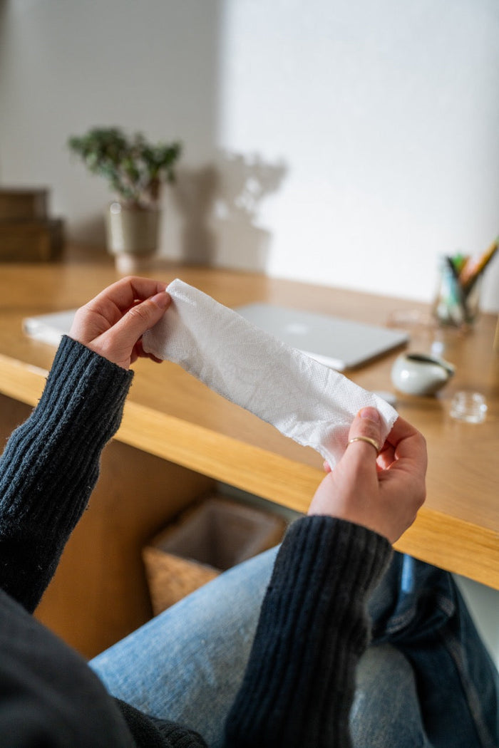 Aromatherapy eye cover, white cloth mask held by hands near the face