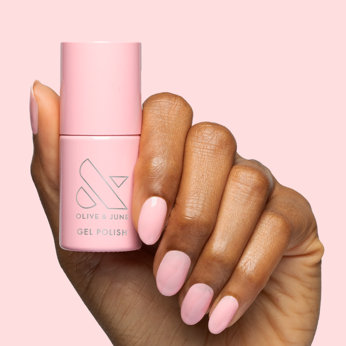 Hand holding Saltwater Taffy - Gel bottle with nails polished in a sheer, sweet pink gel polish shade