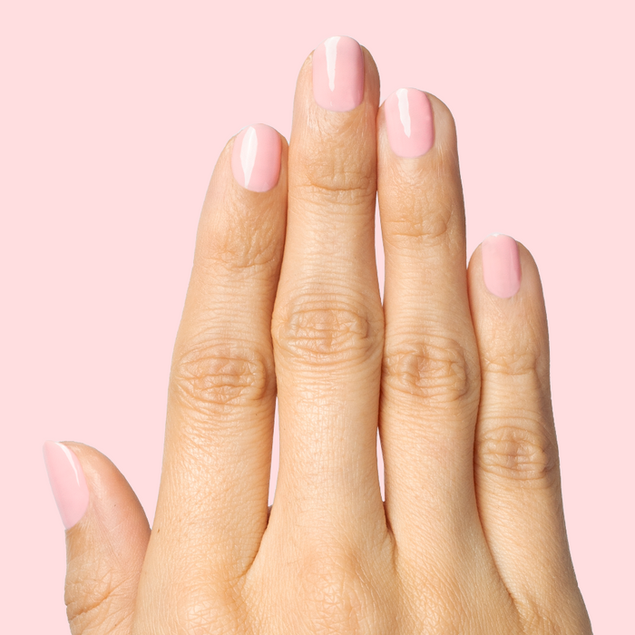 Hand with nails painted in a sheer pink shade using Saltwater Taffy - Gel for a polished at-home manicure look