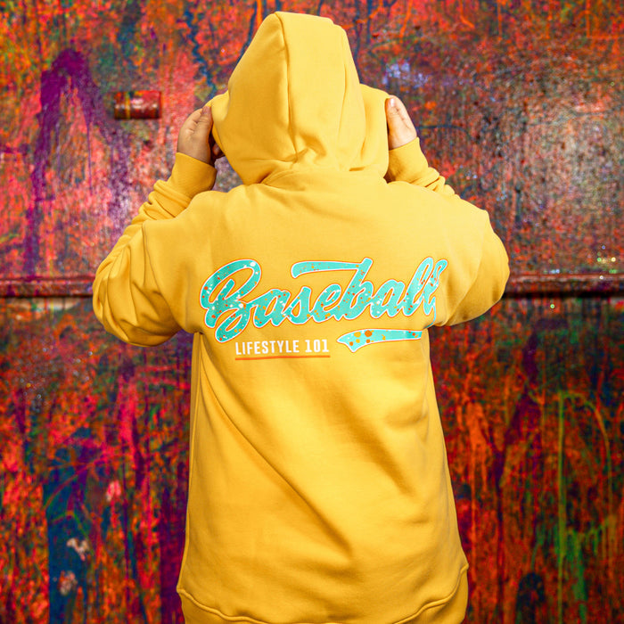 Person wearing a orange hoodie with 'Baseball Lifestyle 101' text on the back against a colorful abstract background.
