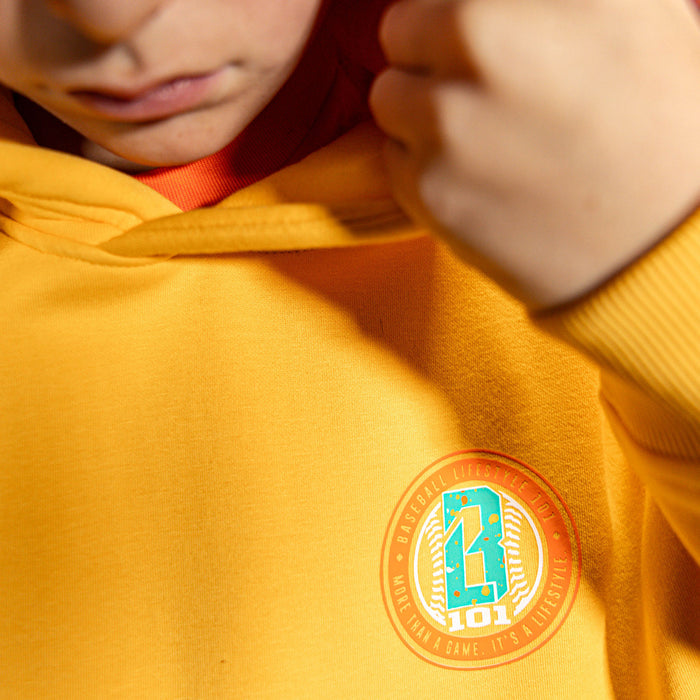 Close up of person wearing a orange hoodie with a BL101 logo on the chest