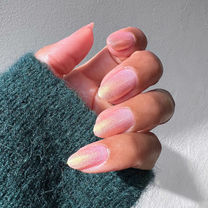 Hand with Sugarcoat sheer shimmery pink iridescent quick dry polish manicure on natural skin in sunlight