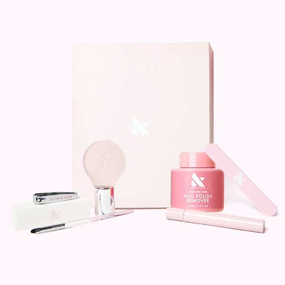 The O&J Mani System - 1 Polish includes acetone-free remover, nail file, clipper, brush, and manicure tools in soft pink packaging