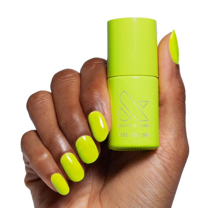 Time To Re-apply - Gel neon yellow green gel polish on hand holding matching bottle for bright manicure look