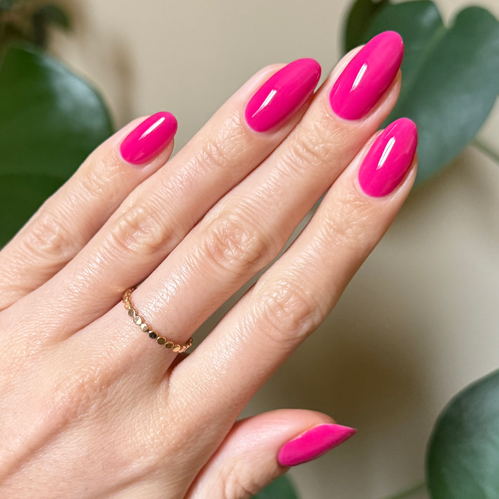Hand with nails painted in glossy bright magenta using Wild Orchid - Gel for a bold, long-lasting manicure look at home